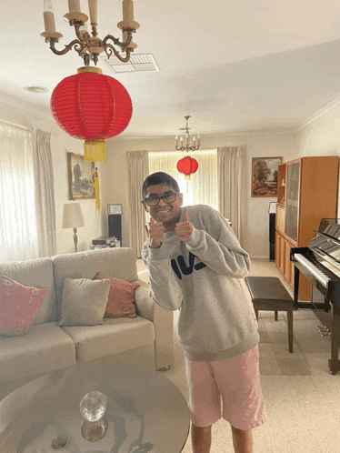 a man wearing a fila sweatshirt giving a thumbs up
