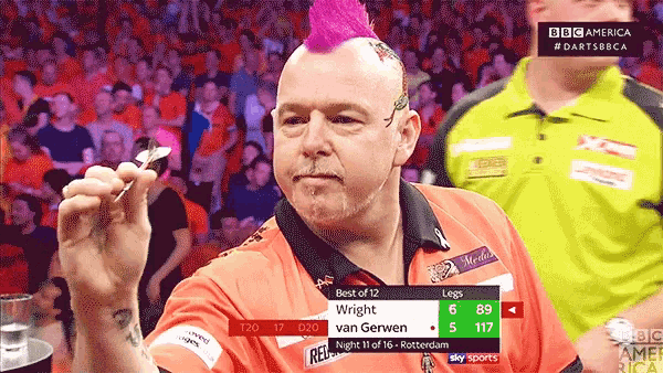 a man with a pink mohawk is holding a dart