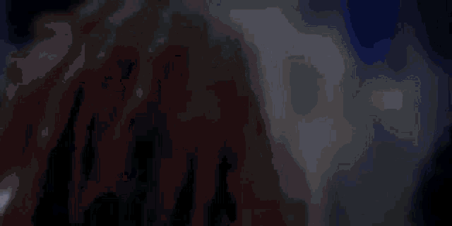 a man and a woman are dancing in a dark room in a blurry photo .