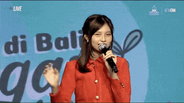 a woman singing into a microphone with the words di bali in the background