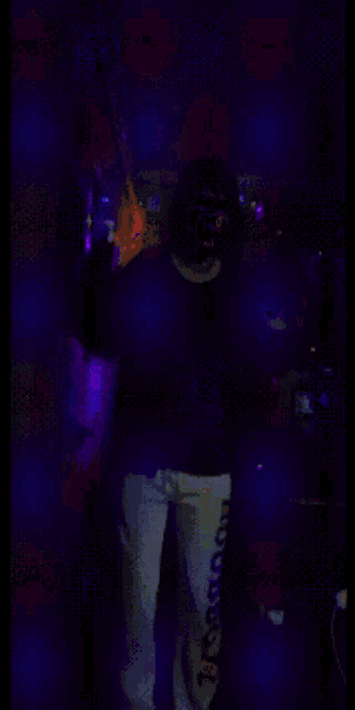 a blurry picture of a person in a dark room with a purple light behind them