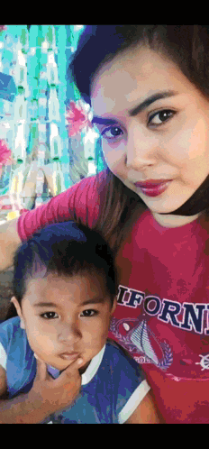 a woman wearing a red california shirt holds a child