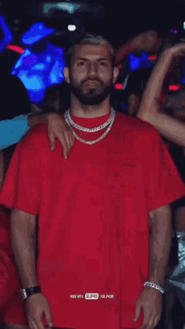 a man with a beard wearing a red t-shirt that says supreme