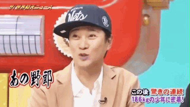 a man wearing a brooklyn mets hat is talking