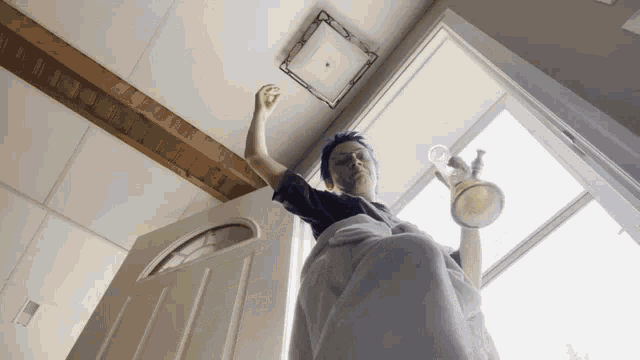 a person hanging upside down in a doorway holding a cup