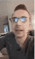 a pixelated image of a man wearing glasses and a shirt