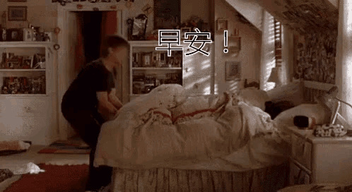 a man is standing next to a bed in a bedroom .