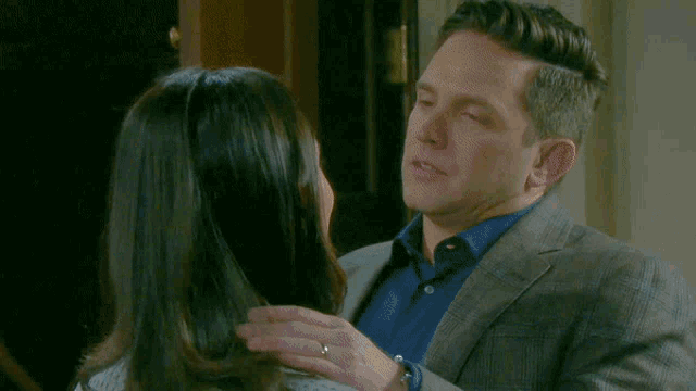 a man in a suit and blue shirt is kissing a woman