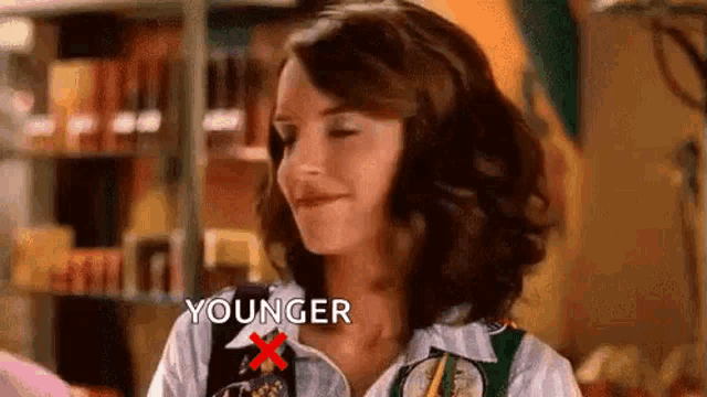 a woman in a striped shirt is smiling and looking at the camera with the word younger crossed out .
