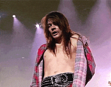 a shirtless man in a plaid shirt is standing on stage