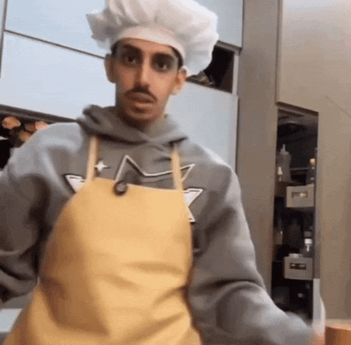 a man wearing a chef 's hat and yellow apron