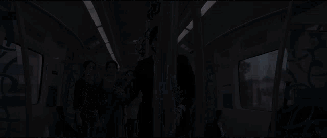a man in a suit is holding a bat on a subway car