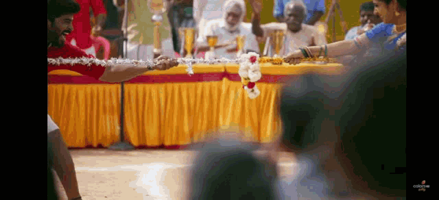 a man and a woman are playing tug of war in front of a crowd