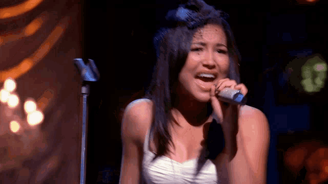 a woman singing into a microphone on stage