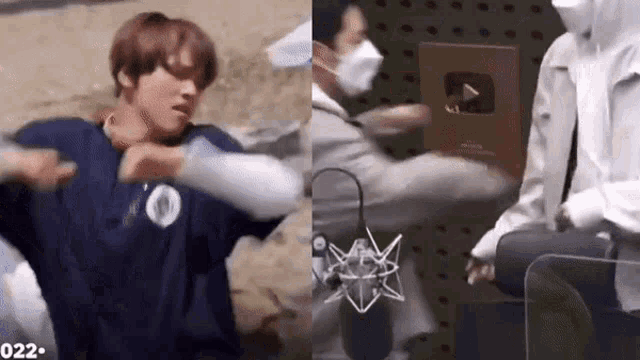 a man in a blue shirt is being punched in the face by another man in a mask .