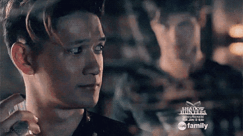 two men are looking at each other in a dark room .