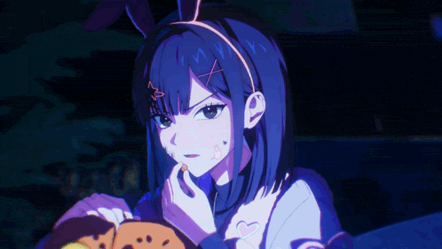 a girl with bunny ears on her head eating a cookie