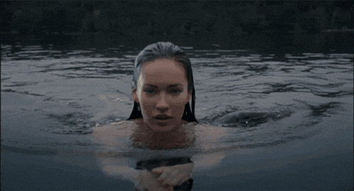 a woman is swimming in a body of water