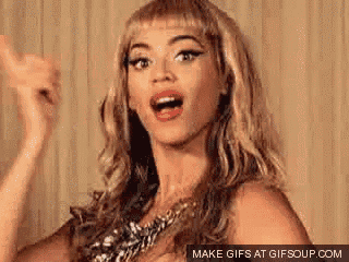 a woman with blonde hair is making a funny face while wearing a gold necklace .