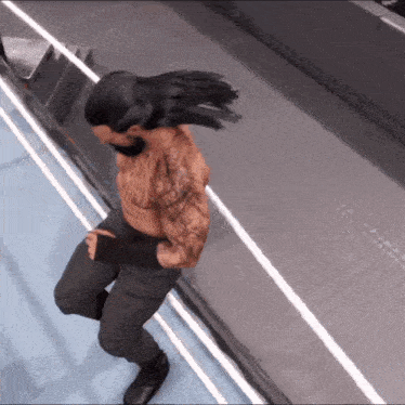 a man with a tattoo on his arm is dancing on a wrestling ring