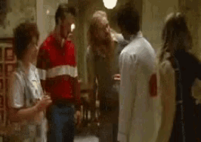 a group of people are standing around a man in a white coat .