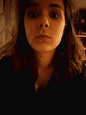 a close up of a woman 's face with her mouth open