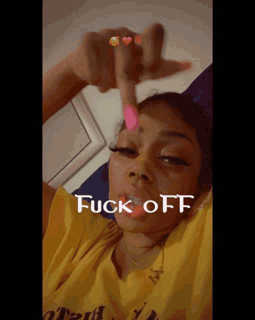 a woman in a yellow shirt with the word fuck off written on her face