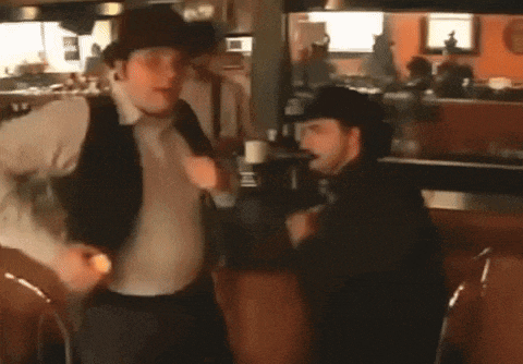a man in a cowboy hat is dancing in a diner