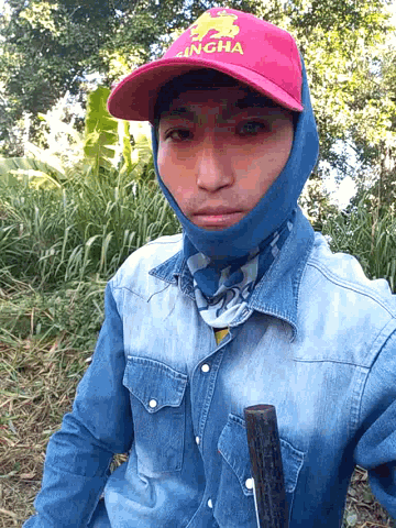 a young man wearing a red bull hat and a blue shirt