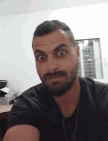 a man with a beard has his eyes wide open