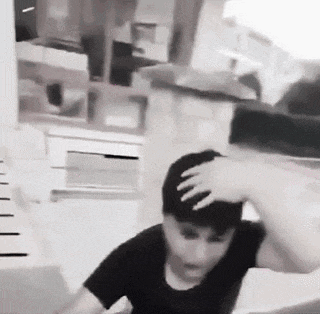 a black and white photo of a man holding his head while standing in front of a measuring tape .