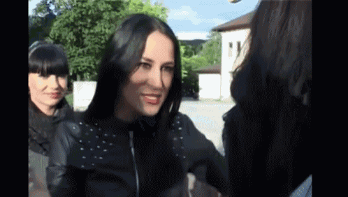 a woman wearing a black leather jacket with studs on it