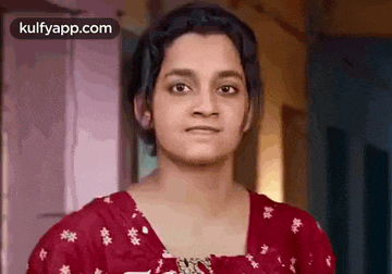 a woman in a red shirt is making a funny face .