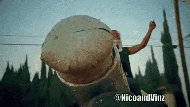 a man is holding a large ball with the hashtag @nicoandvinz on the bottom