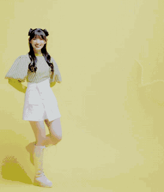 a girl in a green and white striped shirt and white skirt stands on one leg