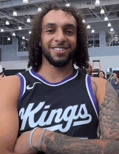 a man wearing a black and purple jersey that says kings