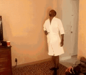 a man in a white robe is dancing in a room