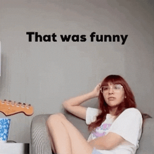 a woman is sitting on a couch in front of a wall with the words `` that was funny '' .