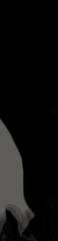 a black and white photo of a person holding a knife in the dark .