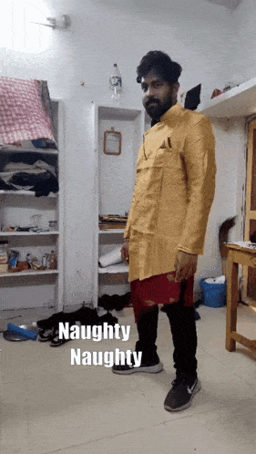 a man standing in a room with the words naughty naughty written on the floor