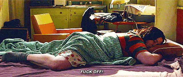 a man is laying on a bed with the word fuck off written on the bottom