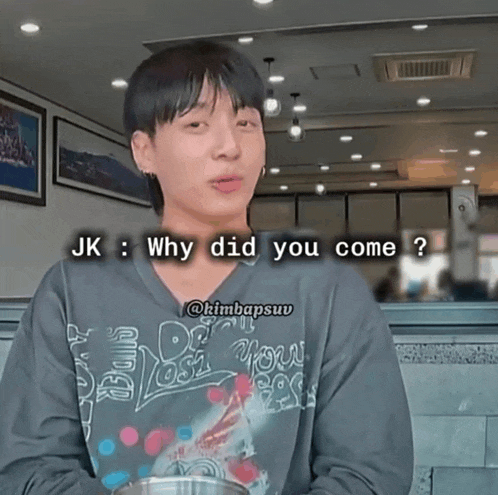 a man wearing a black shirt that says ' why did you come ' on it