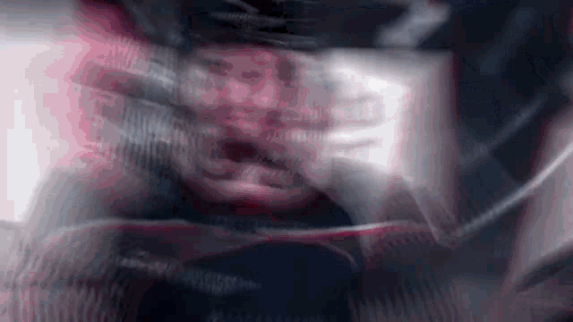 a blurry picture of a man wearing a helmet and a jacket .