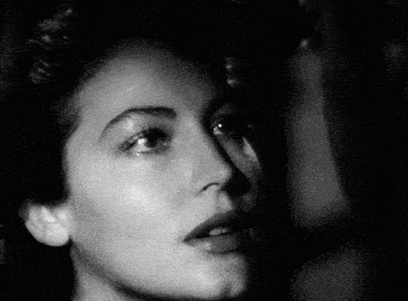 a close up of a woman 's face in a black and white photo