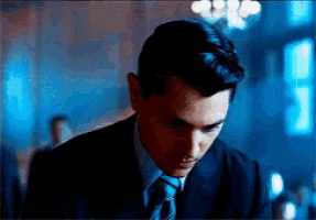 a man in a suit and tie looks down
