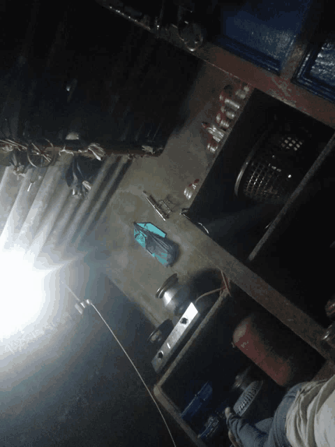 a person standing in a dark room with a light shining through the ceiling