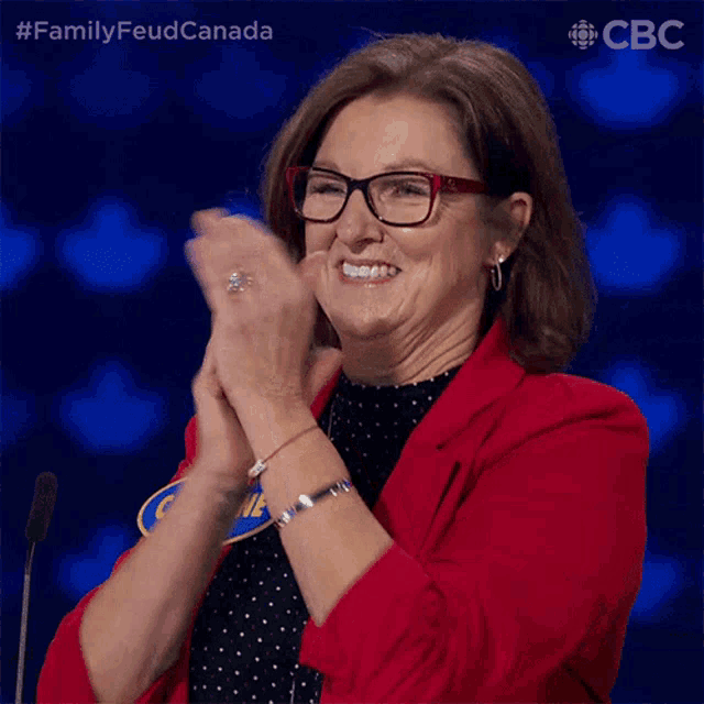 a woman wearing glasses and a name tag that says oline clapping her hands