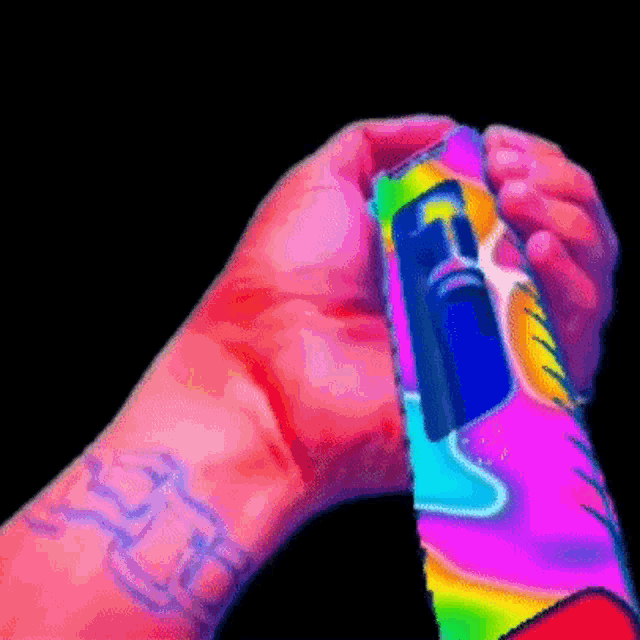a person with a tattoo on their wrist is holding a colorful object in their hand .