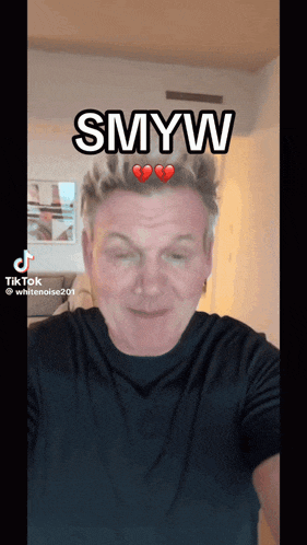 a man in a black shirt has the word smyw on his head