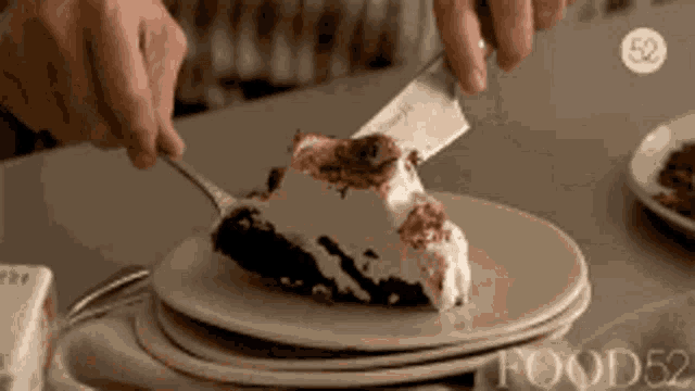 a person is cutting a piece of cake on a plate